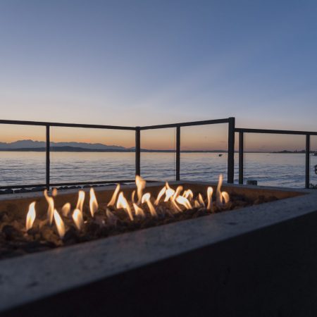 Gas lit backyard fire pit on the beach house outdoor patio at sunset