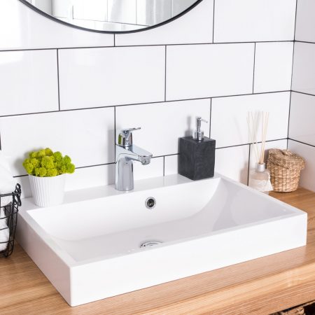 Modern bathroom interior in details. White tile and sink.